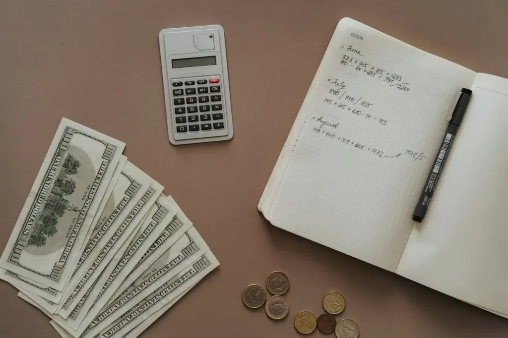Calculadora, billetes y un cuaderno en el que se realiza el cáculo del SDI