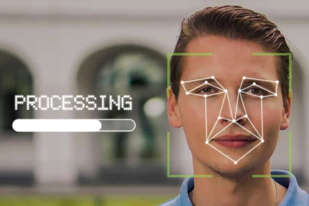 Hombre con el rostro entre unas líneas que forman un cuadrado incompleto y unos puntos y líneas que unen sus ojos, boca y nariz. Al lado aparece la palabra "PROCESSING" y una barra de carga